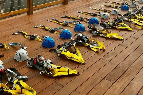 Rows of helmets and safety harnesses laid out on a wooden deck ready for inspection